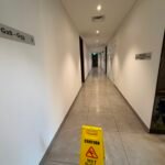 Clean interior corridor with a wet floor safety sign.