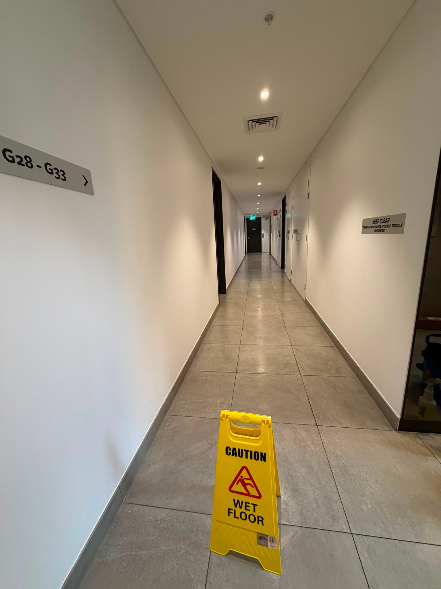 Clean interior corridor with a wet floor safety sign.
