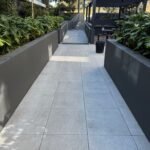 Clean entrance walkway beside planted common areas.