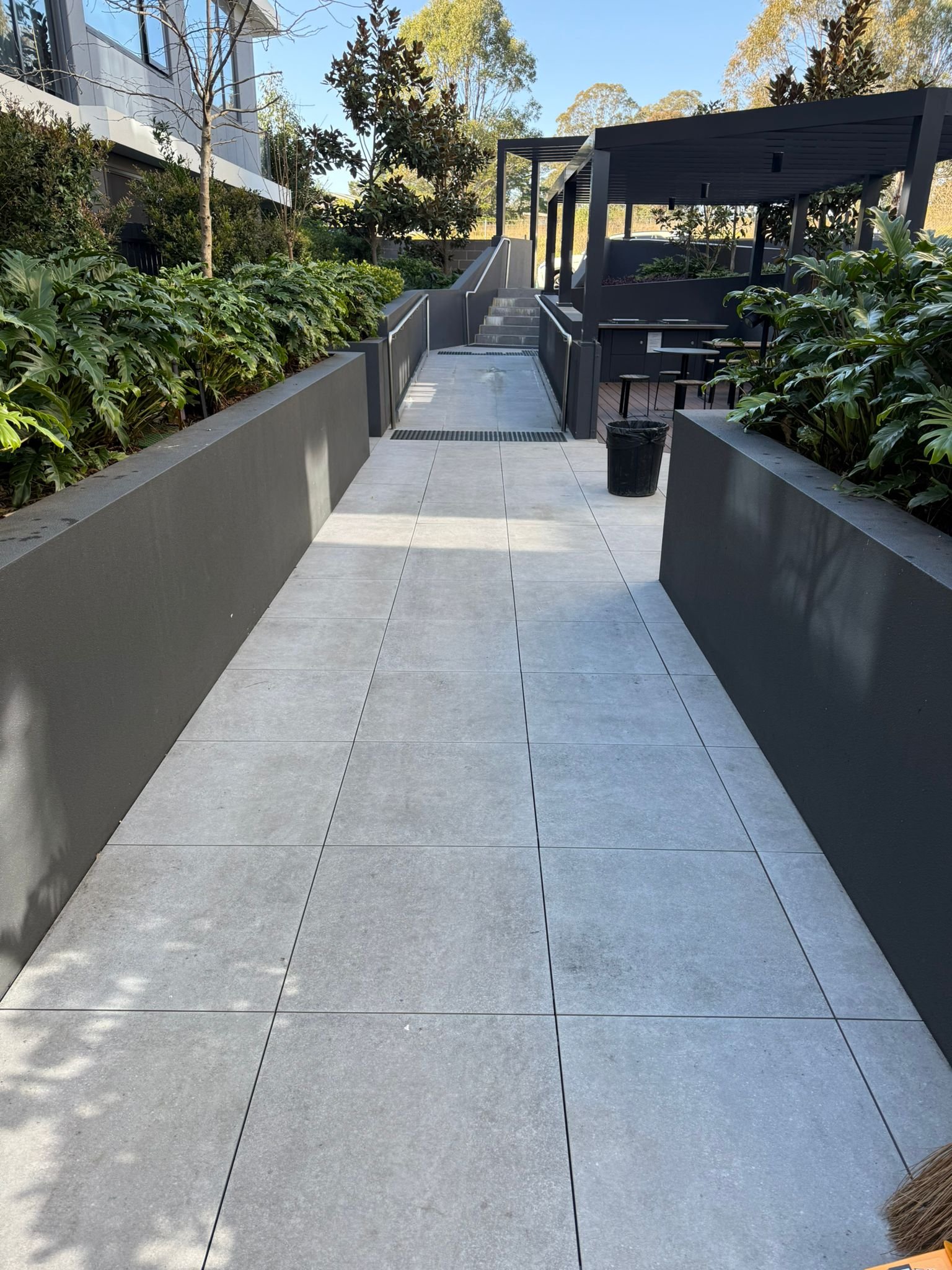 Clean entrance walkway beside planted common areas.