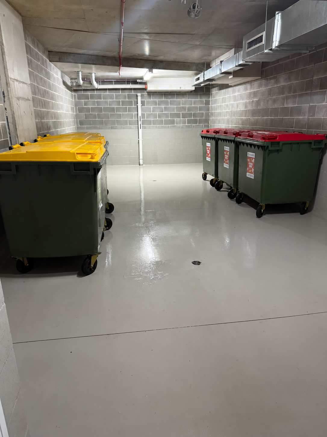Tidy waste room with sorted bins and a clean floor.