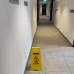 Freshly cleaned strata corridor with wet floor safety sign